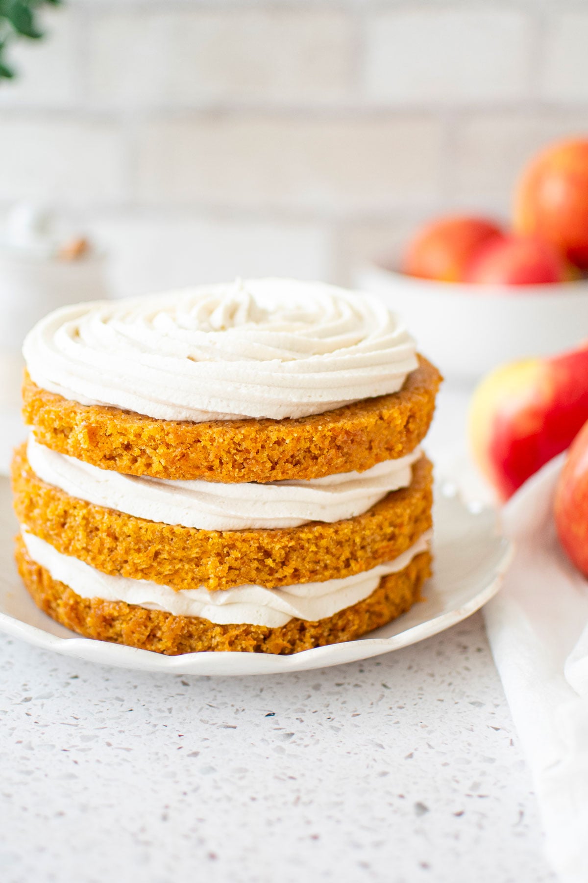 3 layer honey apple carrot cake on a ruffle cake plate.
