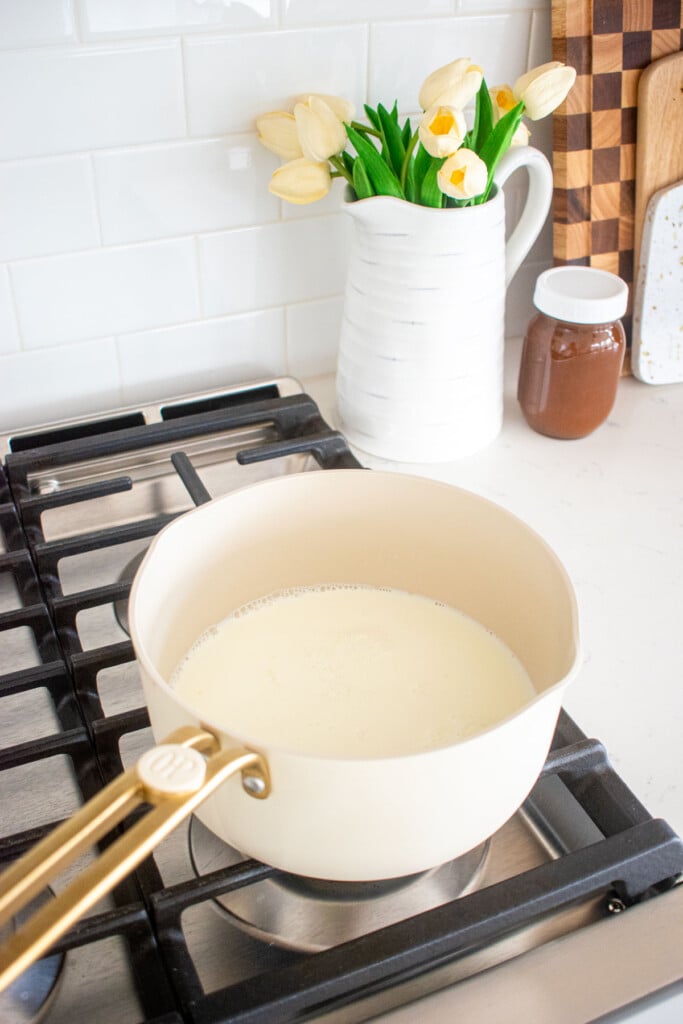 milk, white chocolate and cane sugar in a pot on the stovetop.