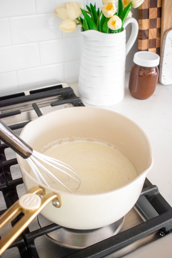 homemade mint fro yo base being whisked over the stovetop.