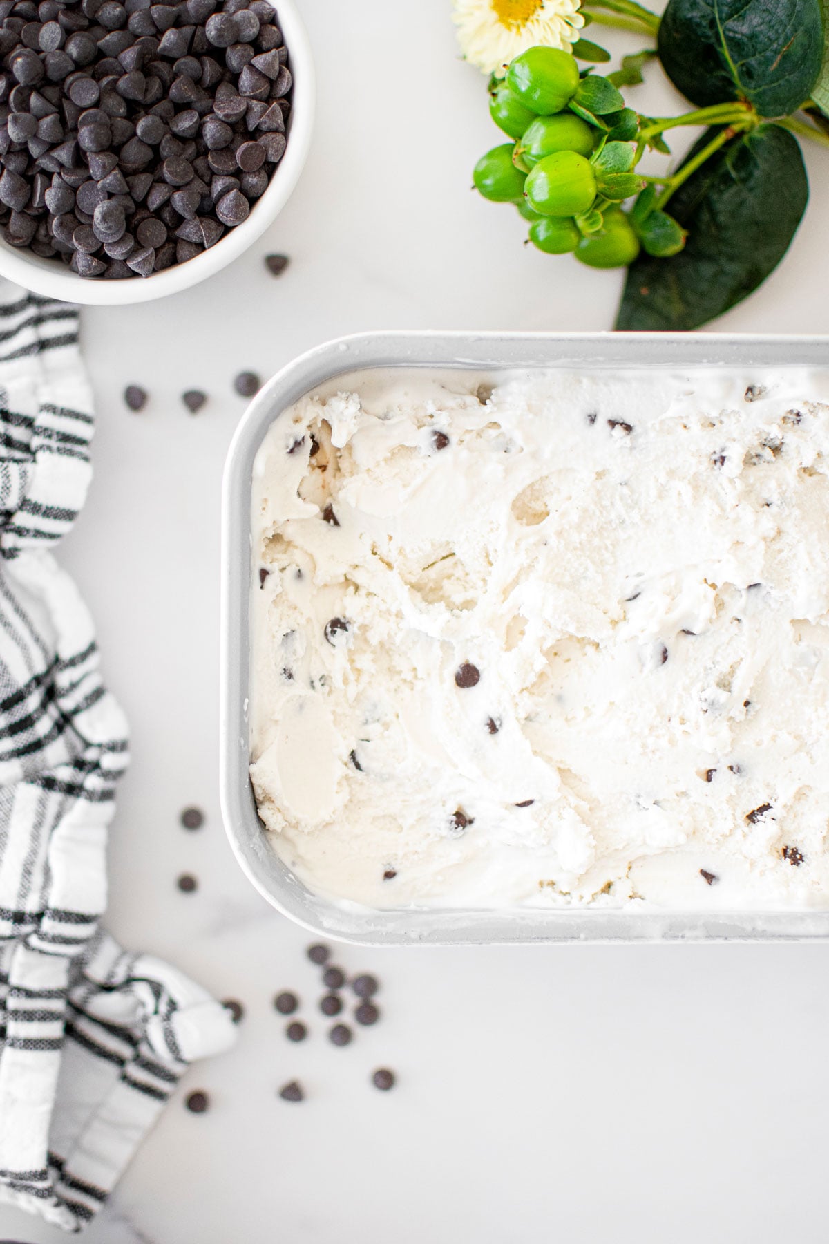 mint chocolate chip fro yo in a loaf pan on a white marble counter.