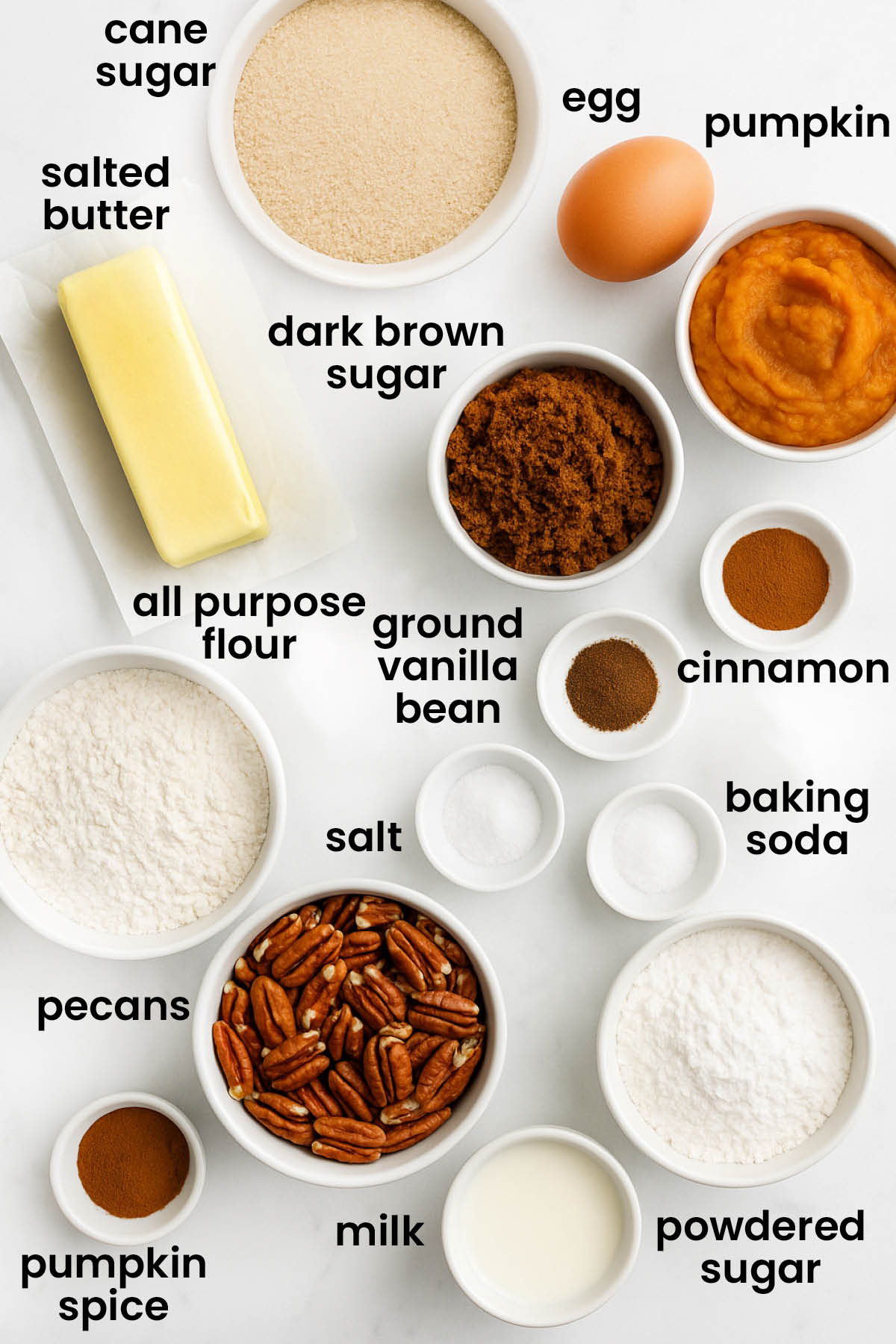 individual ingredients for frosted pecan pumpkin spice cookies on a white marble kitchen countertop.