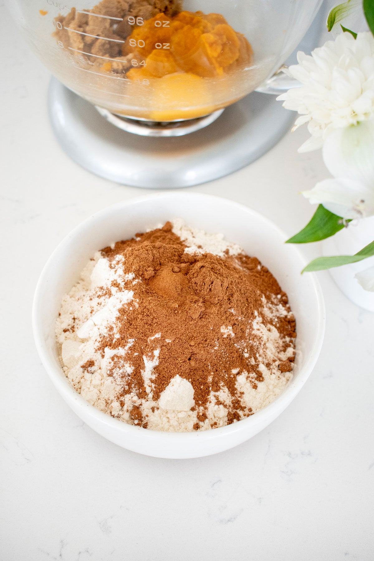 dry ingredients in a bowl on a white marble counter.