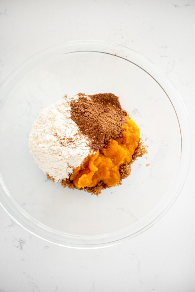 pumpkin pop tart filling ingredients in a glass mixing bowl on a white marble counter.