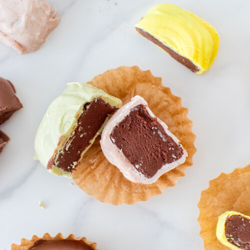 mint meltaway cut in half on a white marble counter revealing a creamy mint chocolate center.