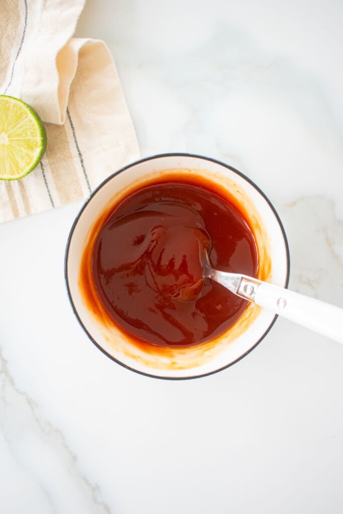 soy lime ketchup in a small bowl on a marble counter.