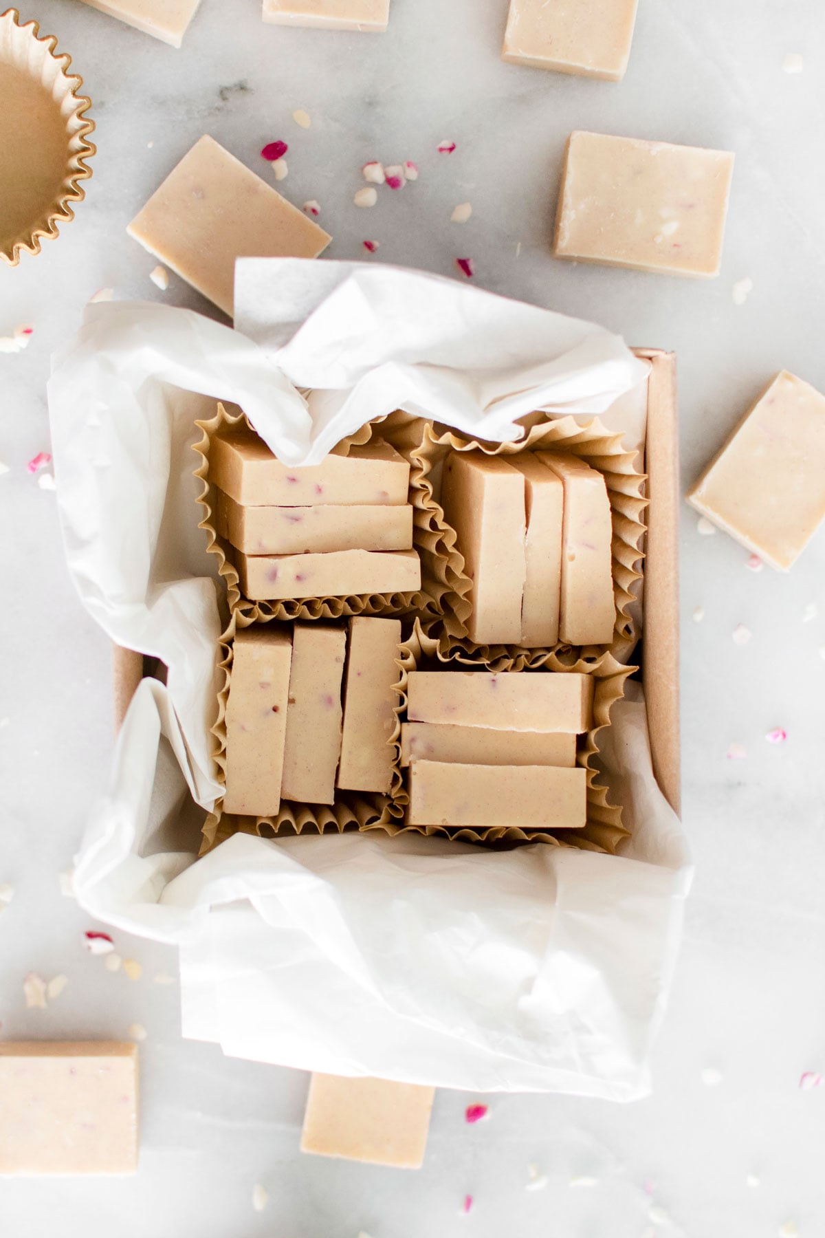 pink peppermint ice in a brown candy box on a white marble counter.