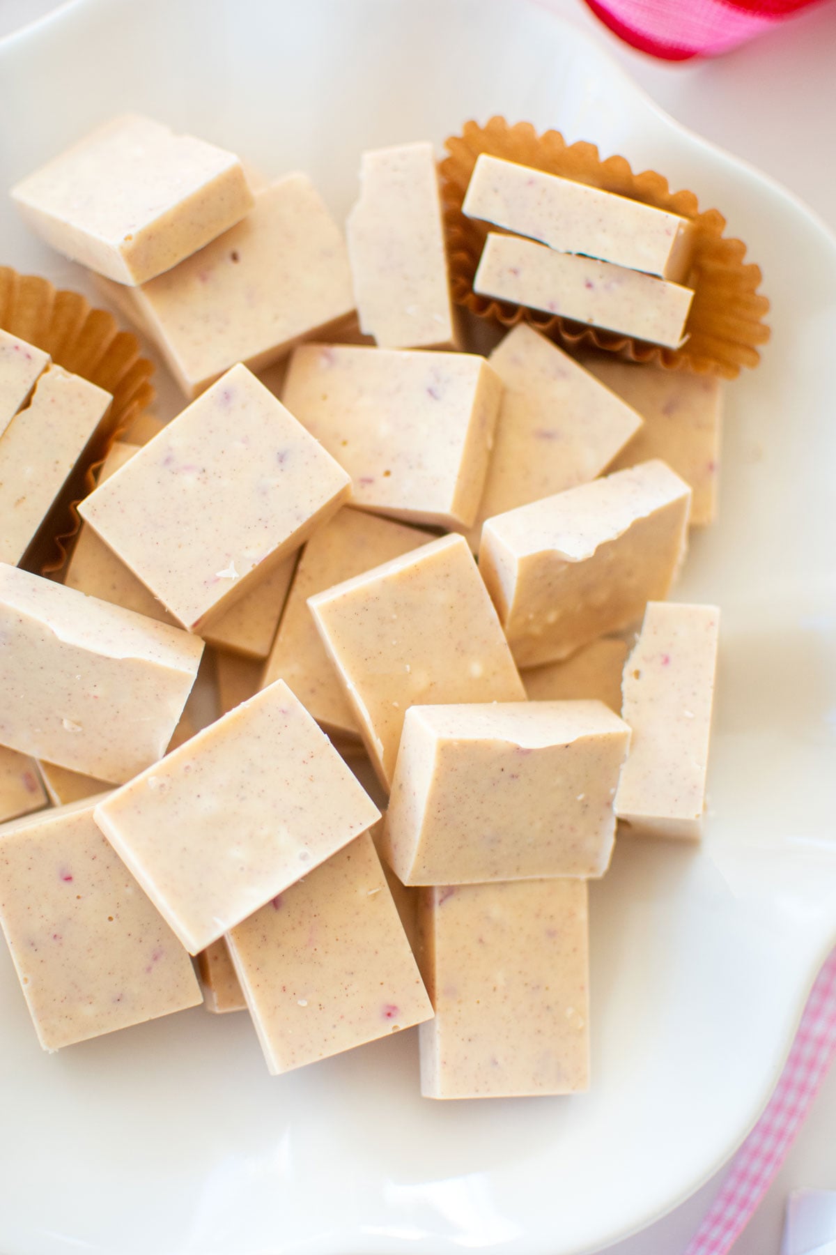 pink peppermint ice squares on a white ruffle plate on a marble counter.