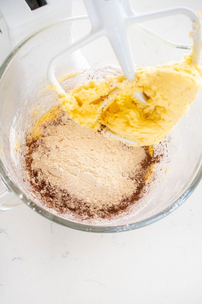 ingredients for homemade organic thin mint cookies in a glass mixing bowl on a marble counter.