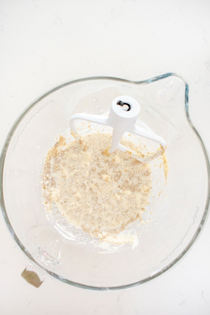 ingredients for eggless strawberry shortcake batter in a glass mixing bowl on a white marble countertop.