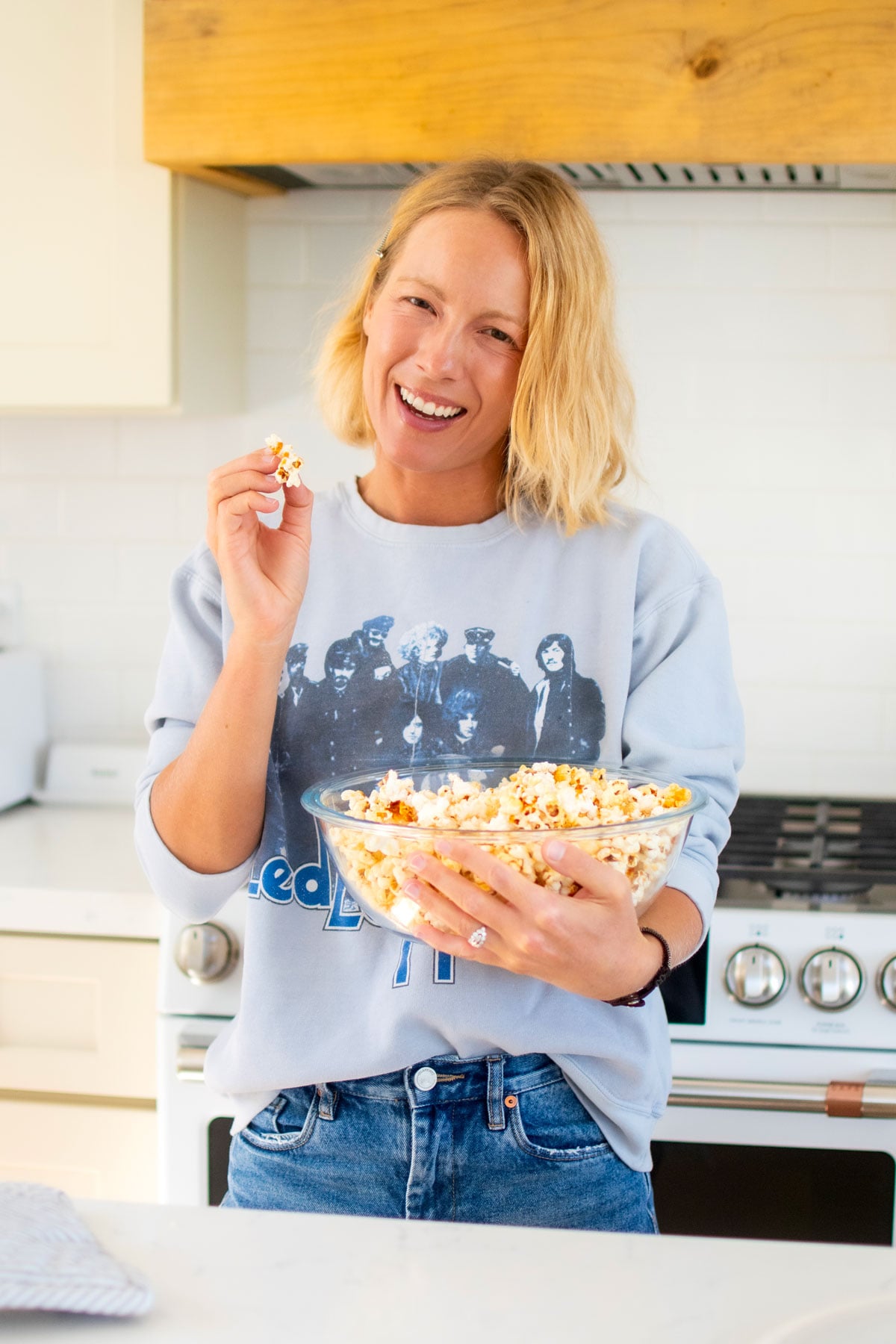 woman eating homemade kettle corn at the kitchen counter.