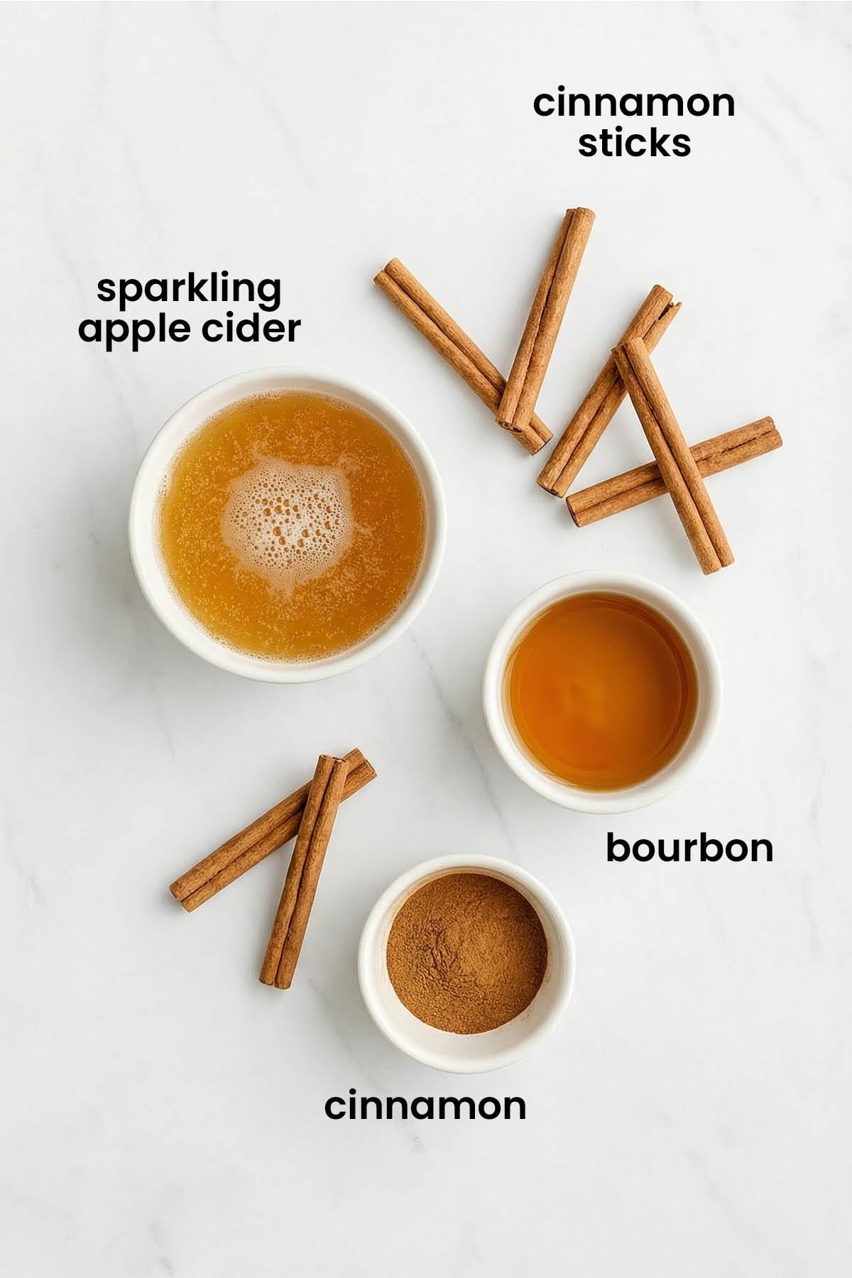 individual ingredients for sparkling apple cider bourbon laid out against a white background.