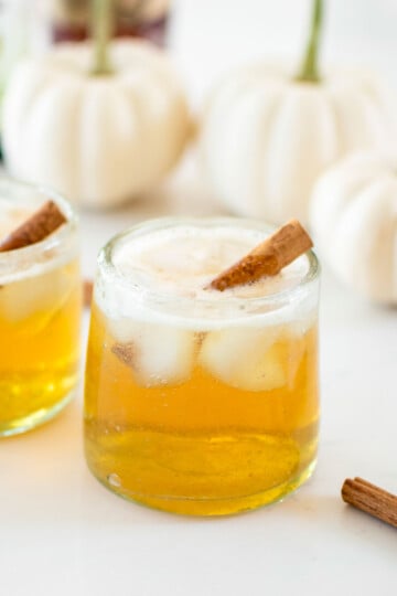sparkling apple cider bourbon with cinnamon stick in a glass.