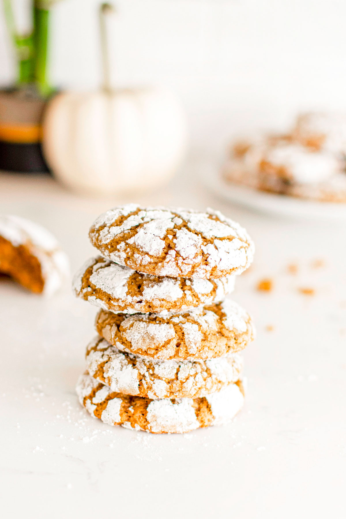 stack of pumpkin spice crinkle cookies on a white marble counter.