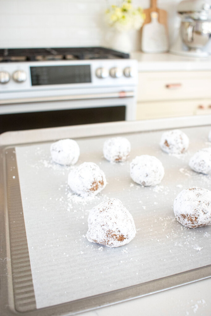 pumpkin spice crinkle cookie dough on a baking sheet on a kitchen counter.