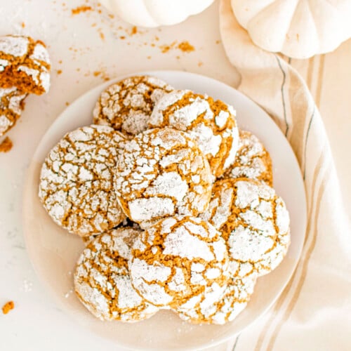 plate of pumpkin spice crinkle cookies on a white marble counter.