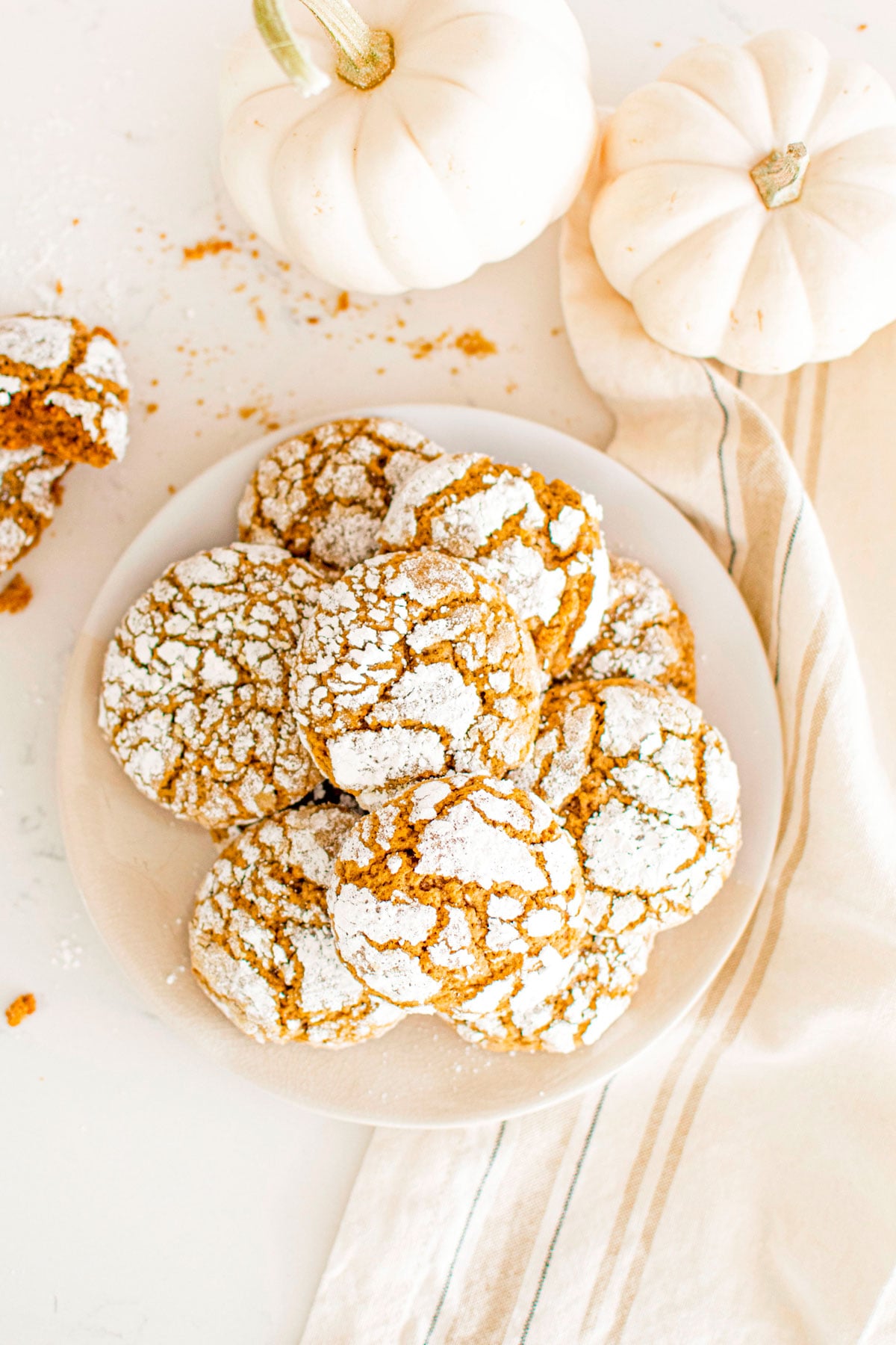 plate of pumpkin spice crinkle cookies on a white marble counter.