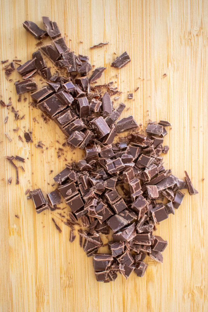 chopped milk chocolate on a bamboo cutting board.