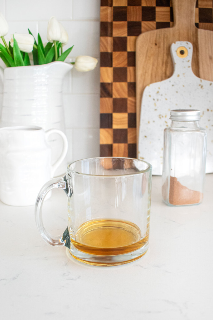 bourbon in a glass mug on a white countertop.