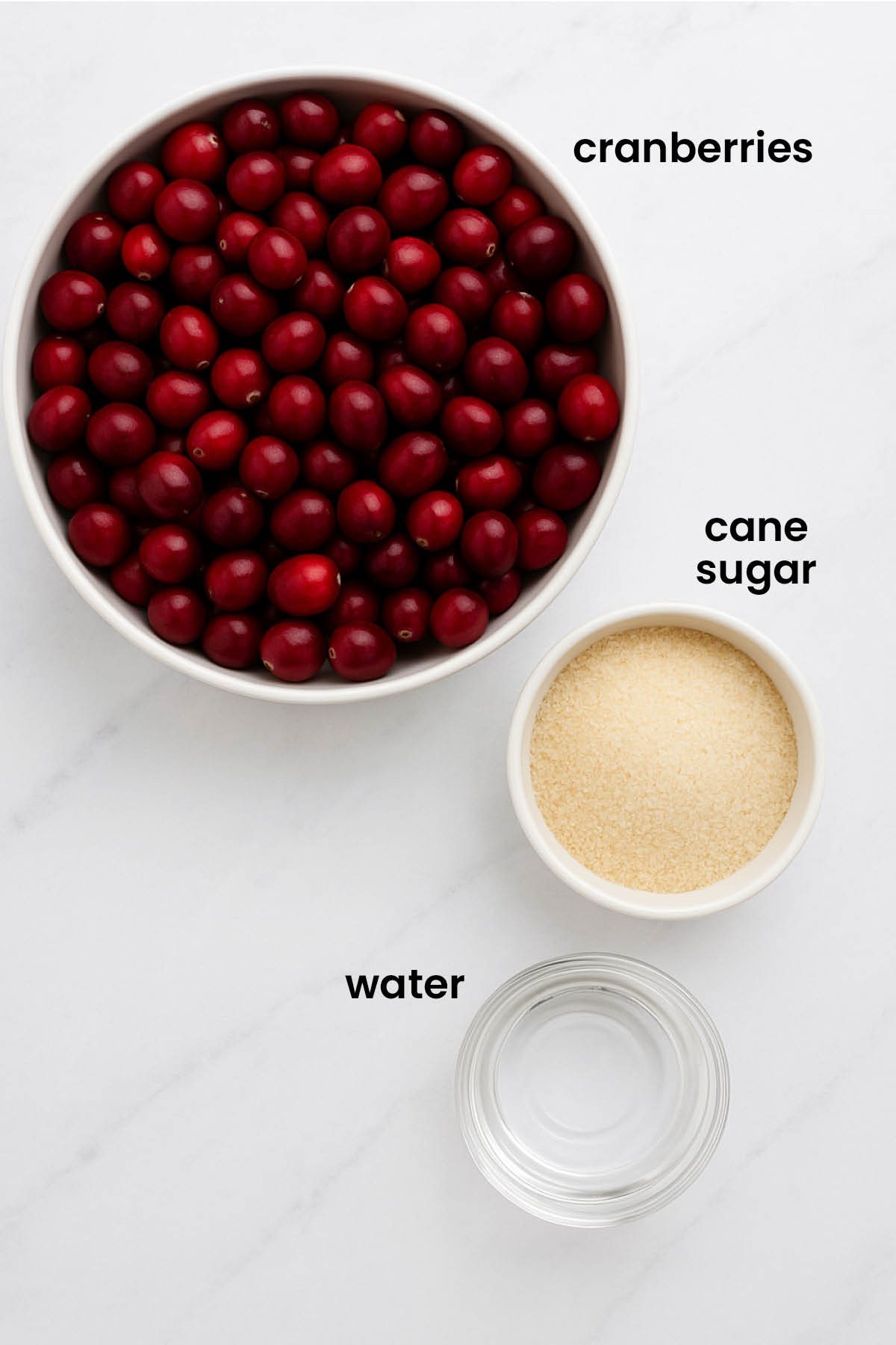 individual ingredients for homemade sugared cranberries laid out against a white background.