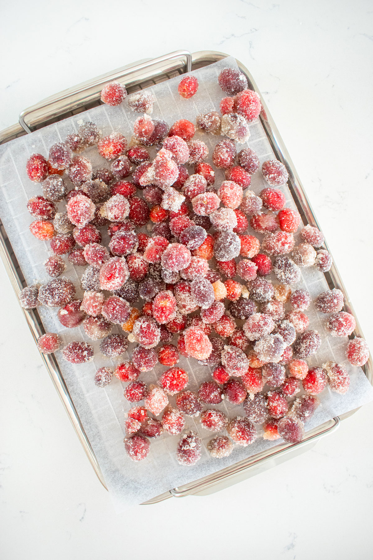 homemade sugared cranberries on a baking sheet.