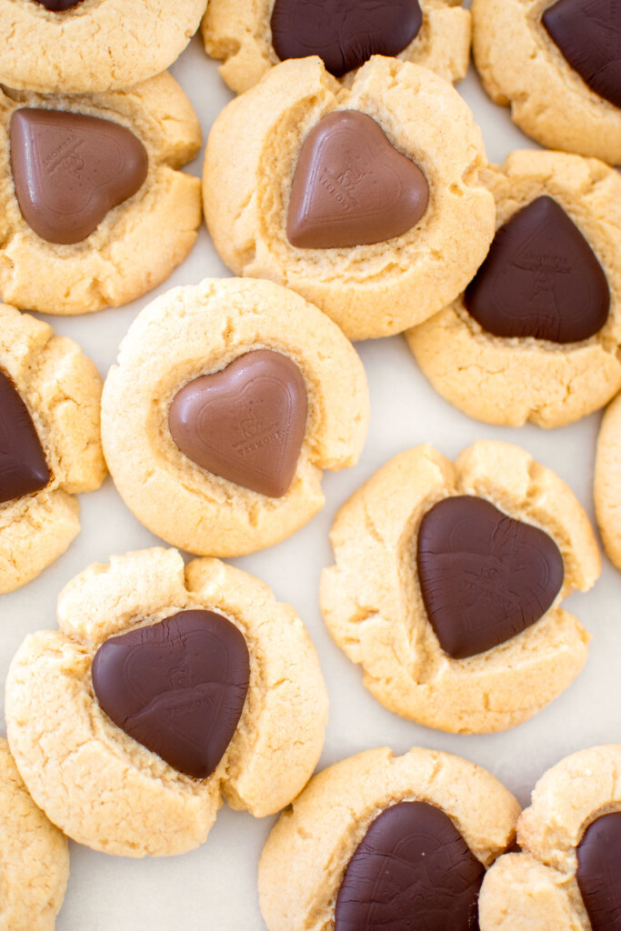 chocolate heart thumbprint cookies on a baking sheet.