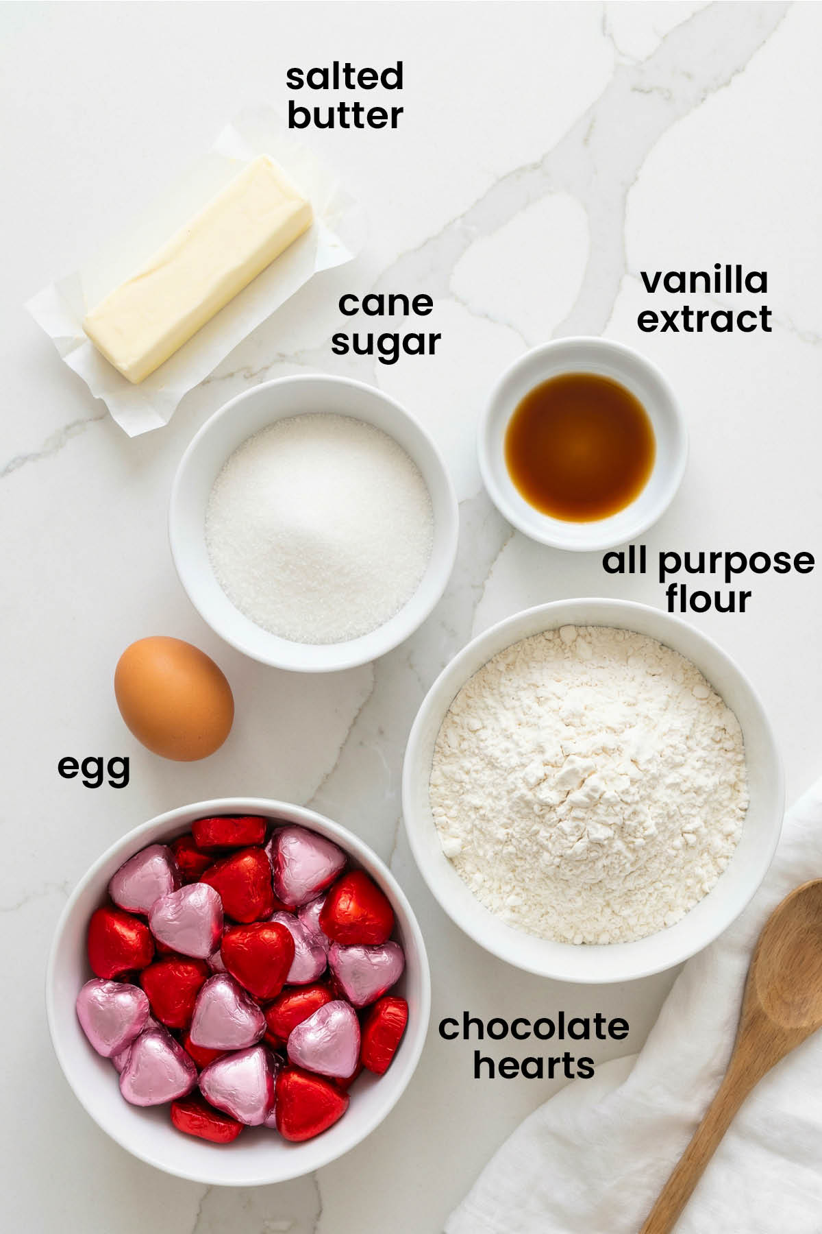 individual ingredients for chocolate heart thumbprint cookies laid out against a white background.