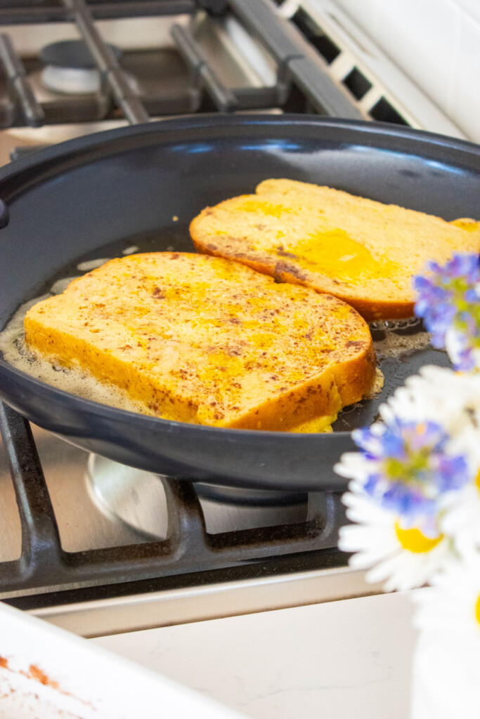 cooked meyer lemon french toast in a black skillet on the stovetop.