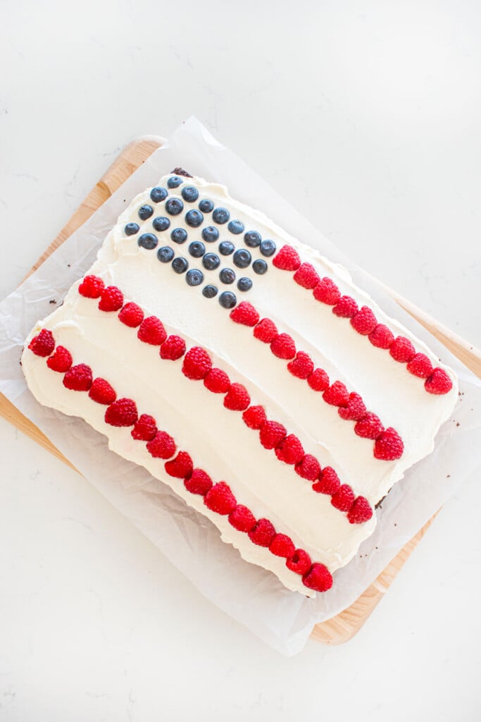 chocolate berry flag cake assembled on a white marble counter.