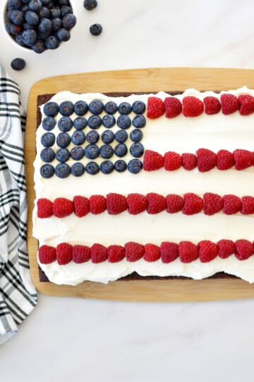 chocolate berry flag cake on a wood serving board on a marble counter.