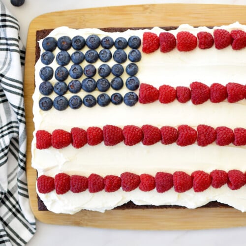 chocolate berry flag cake on a wood serving board on a marble counter.