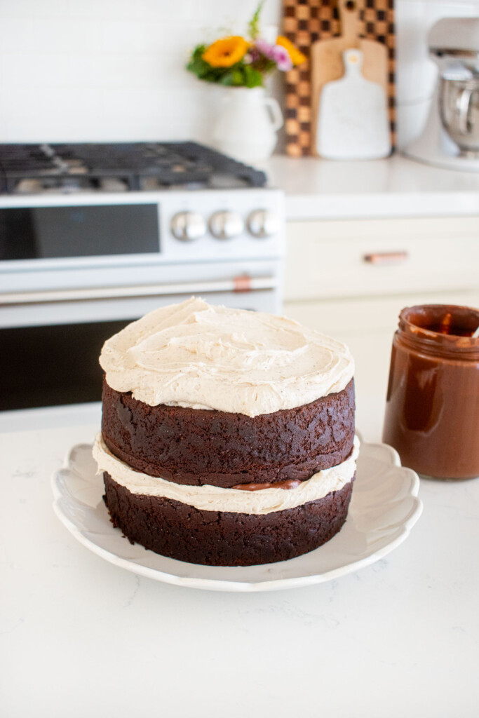 vegan sweet potato chocolate cake being assembled on the kitchen counter.