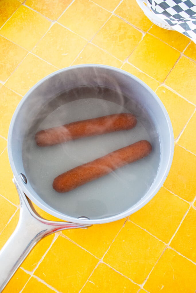 two boiled hot dogs in a smal pot.