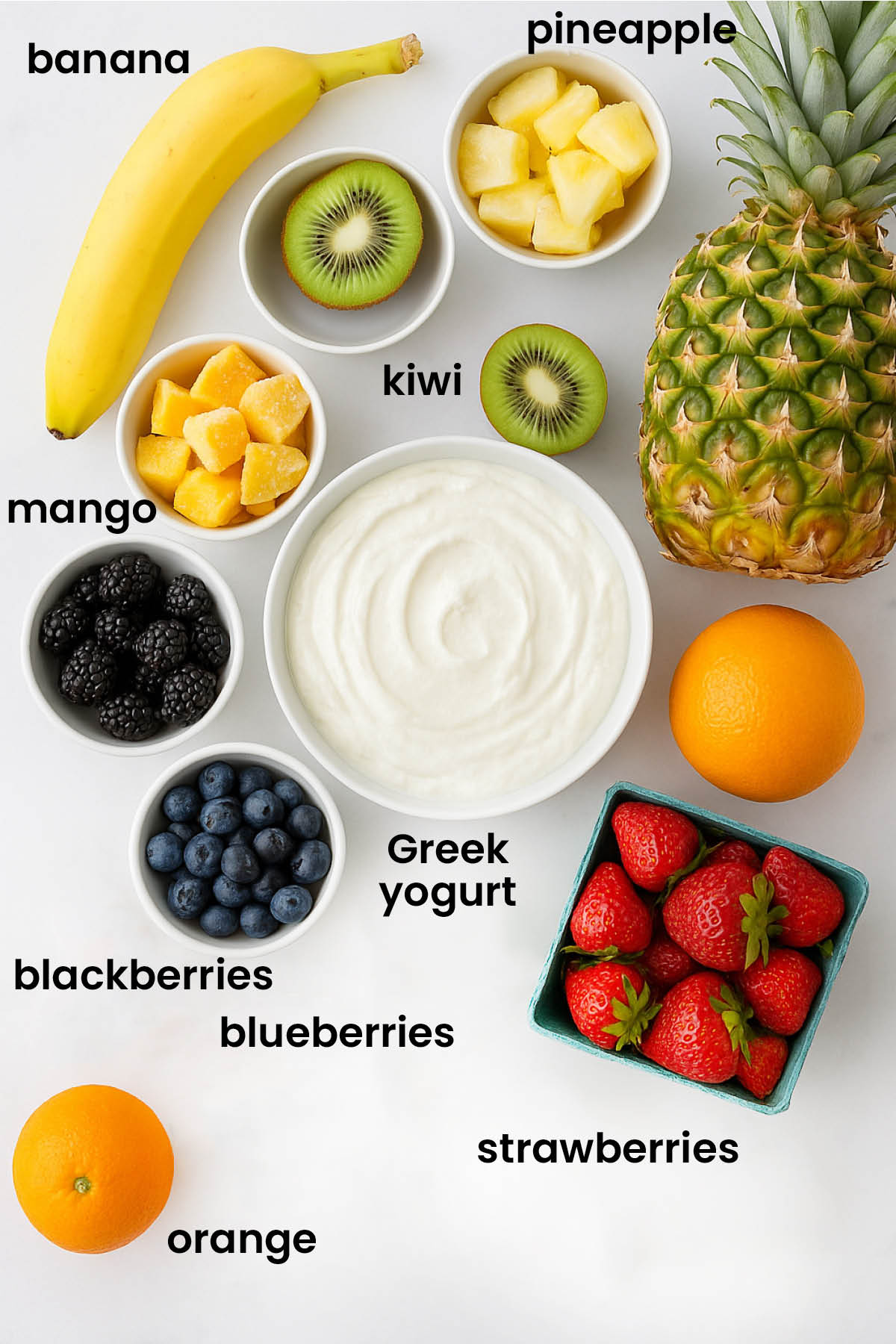 individual ingredients for rainbow smoothie bowl with greek yogurt laid out against a white background.