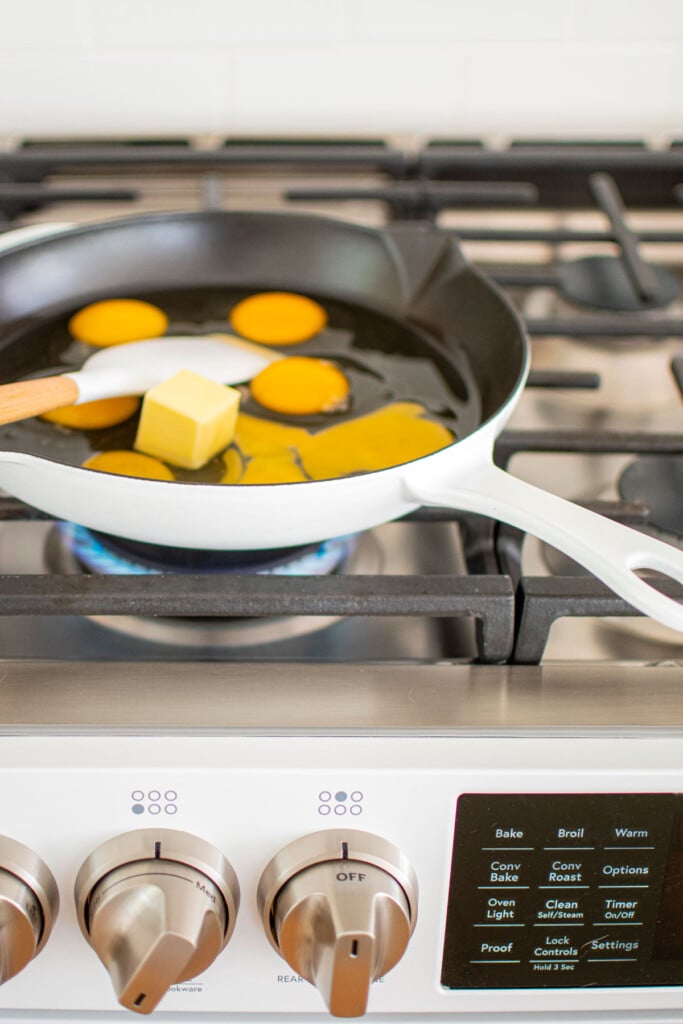 eggs and butter in a cast iron skillet on the stovetop.