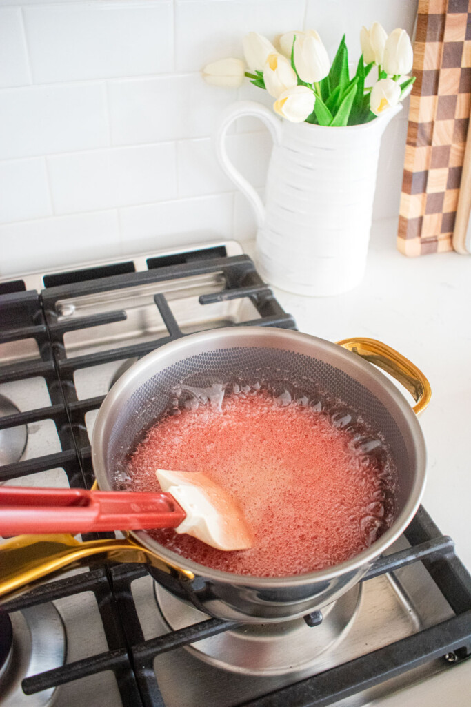 homemade cherry marshmallows being boiled in a pot on the stovetop.