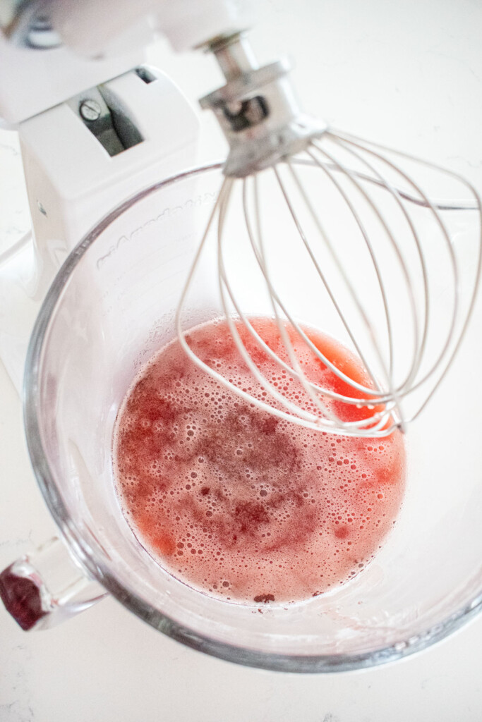 homemade cherry marshmallow ingredients in a glass mixing bowl on a white marble counter.