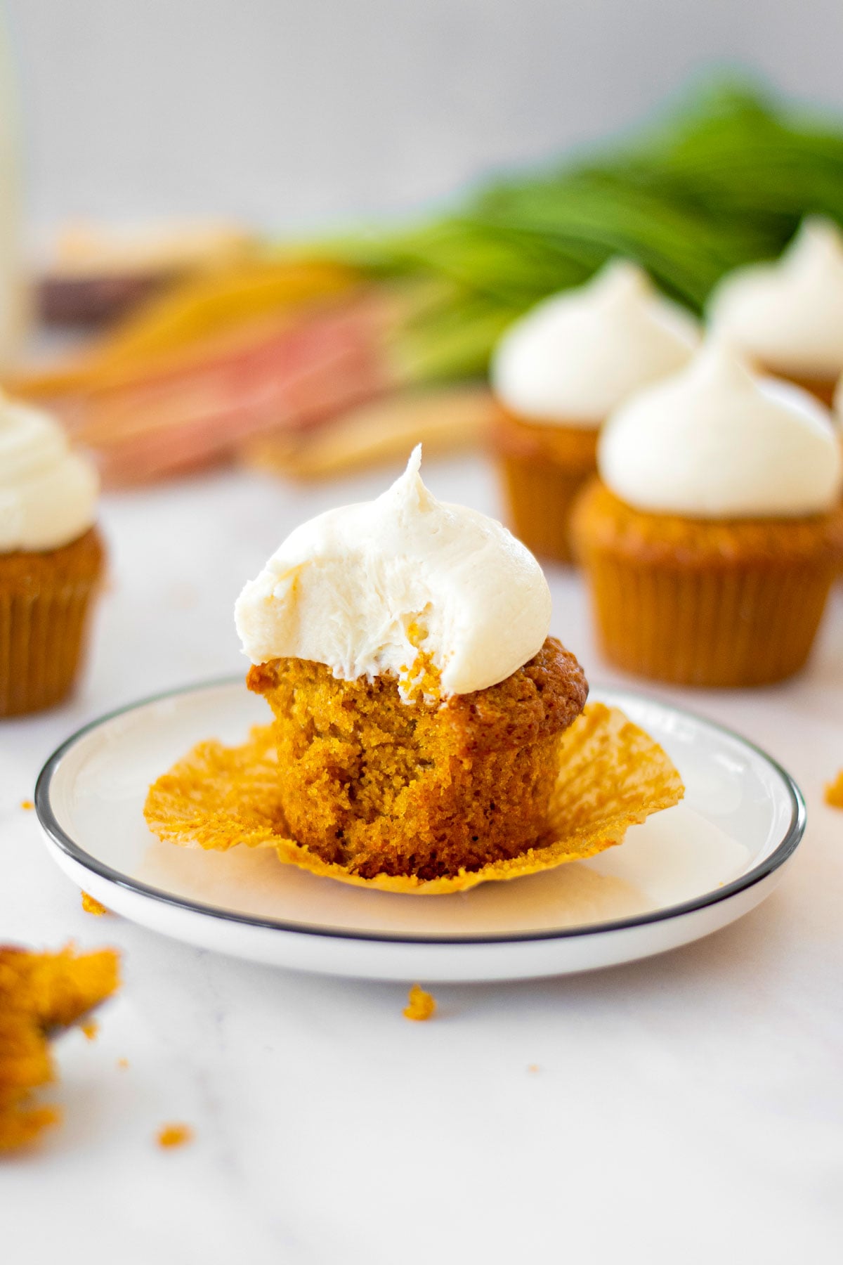 brown sugar carrot cupcake on a plate with a bite taken out of it.