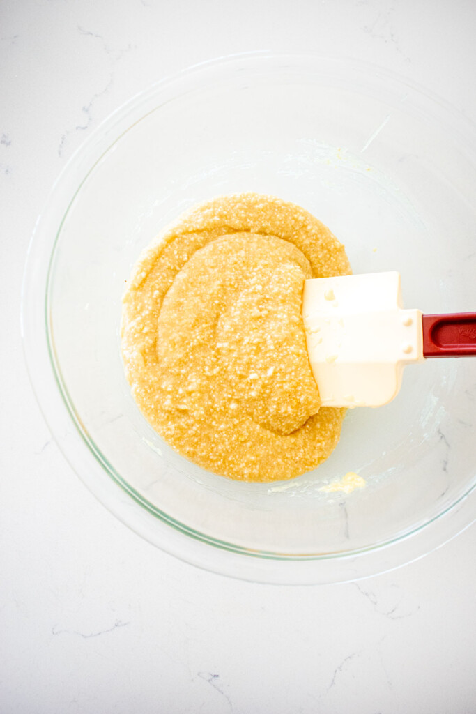 florentine cookie batter in a glass mixing bowl on a marble counter.
