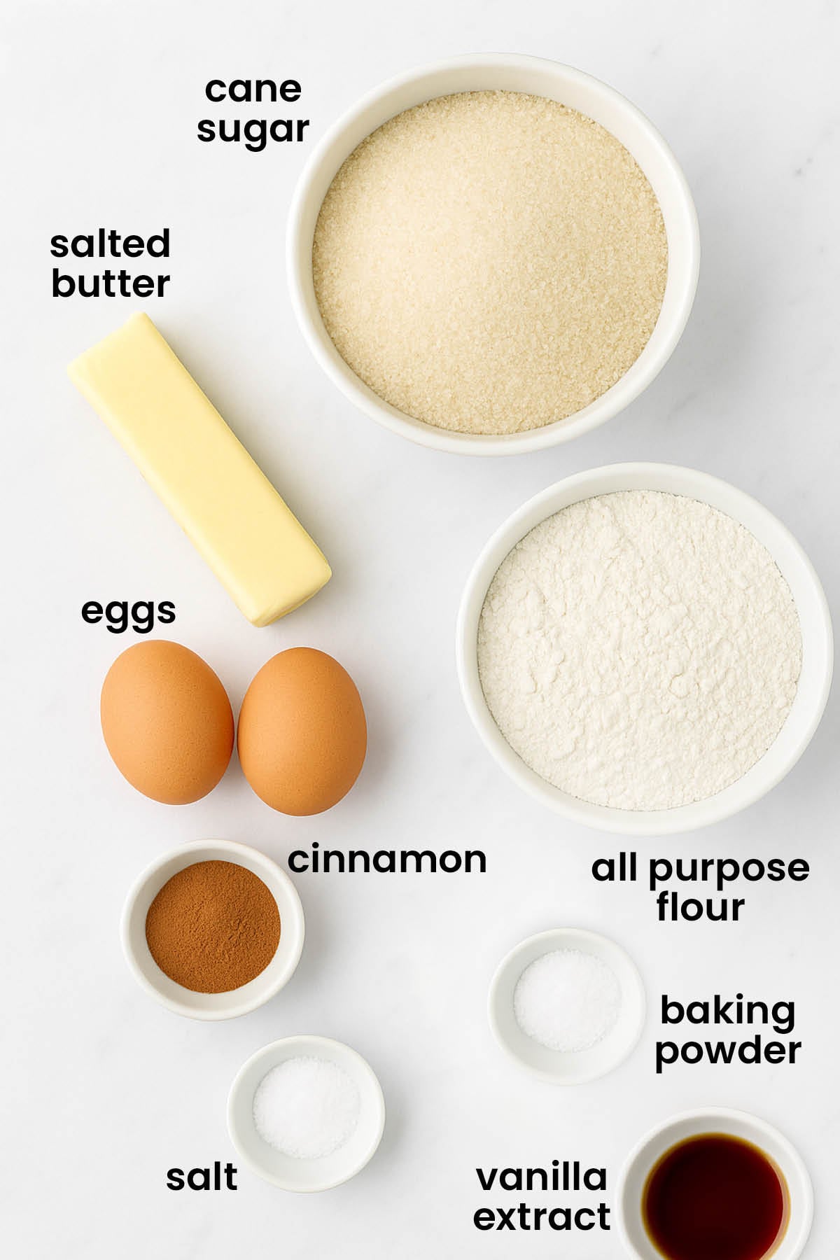 individual ingredients for snickerdoodle biscotti on a white marble kitchen countertop.
