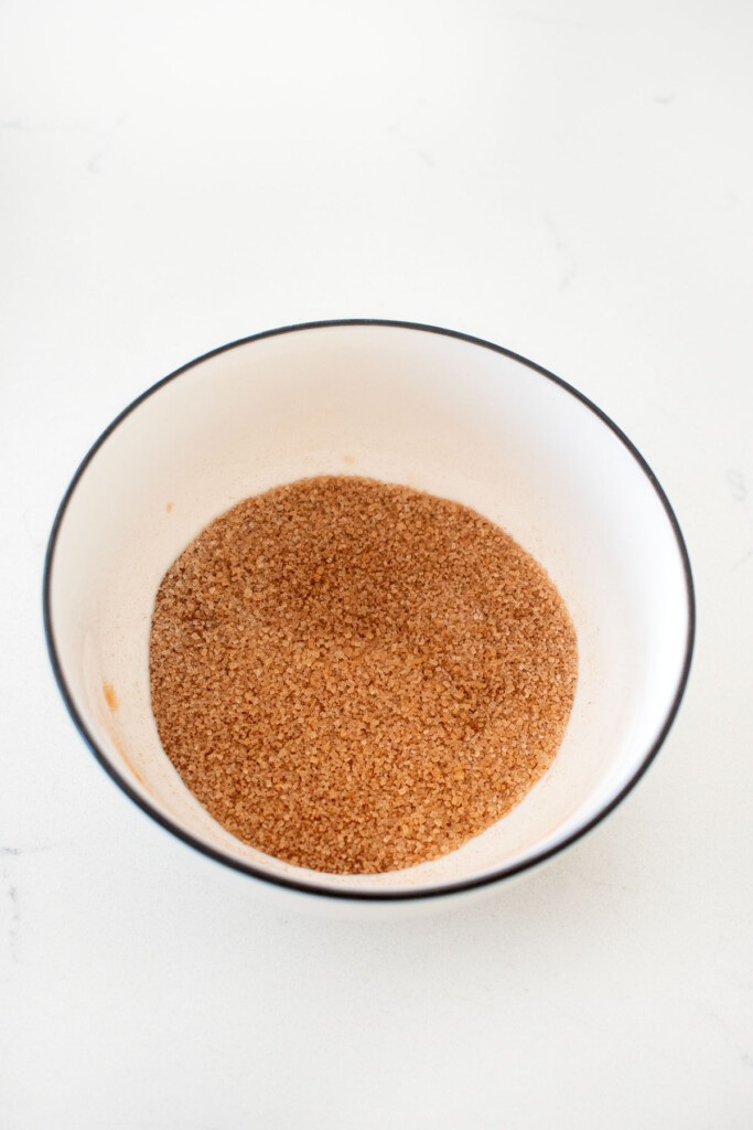 bowl of cinnamon and sugar on a white marble counter.