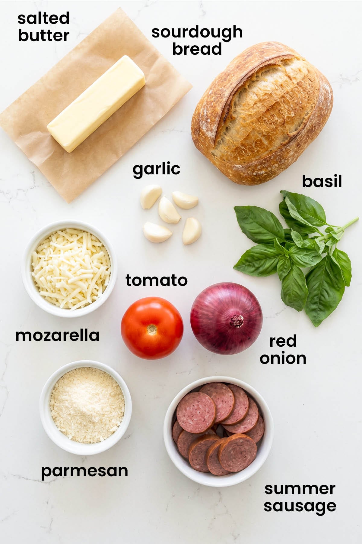 individual ingredients for air fryer loaded garlic bread laid out against a white background.