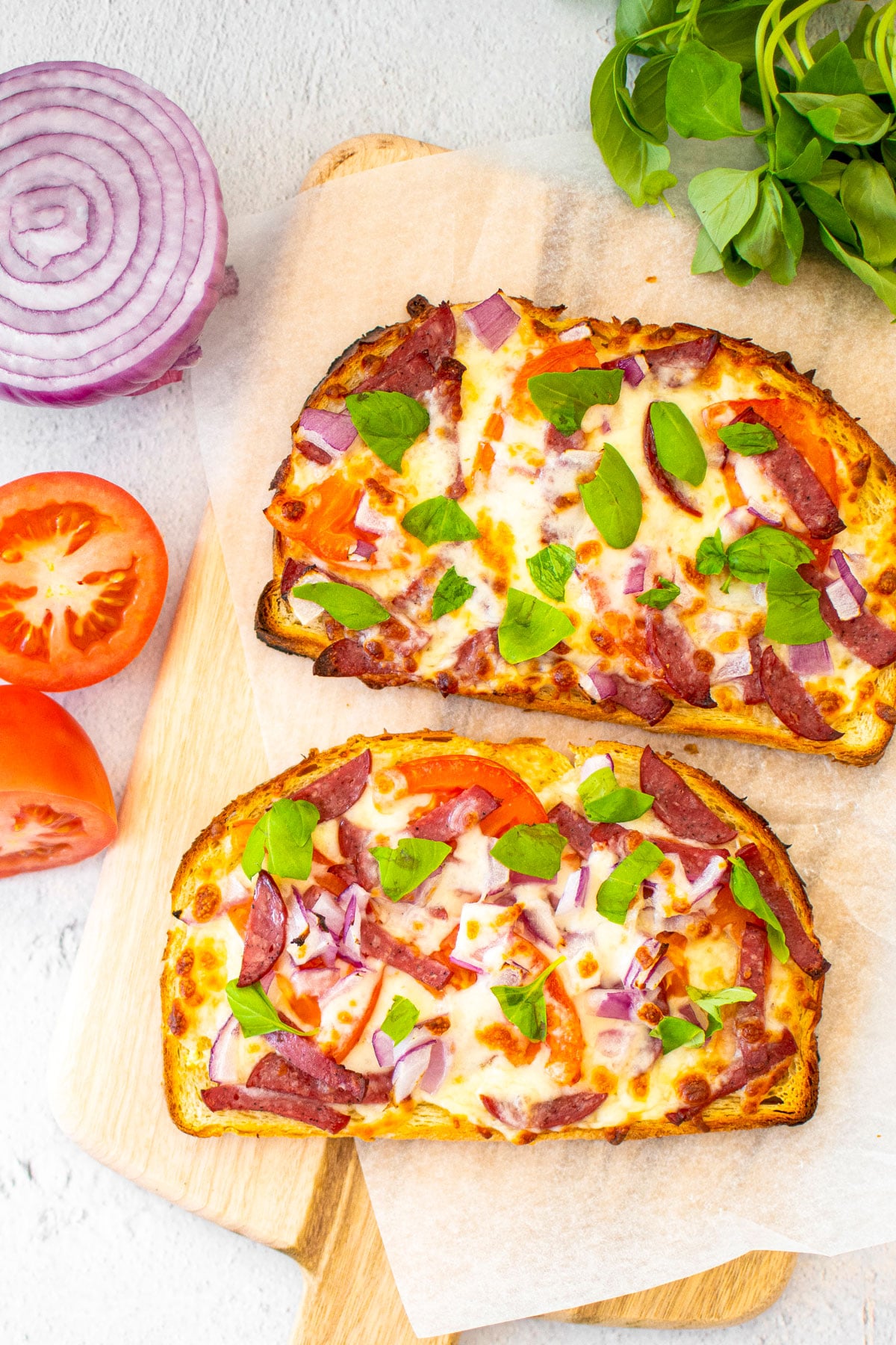 air fryer loaded garlic bread slices on a wood cutting board.