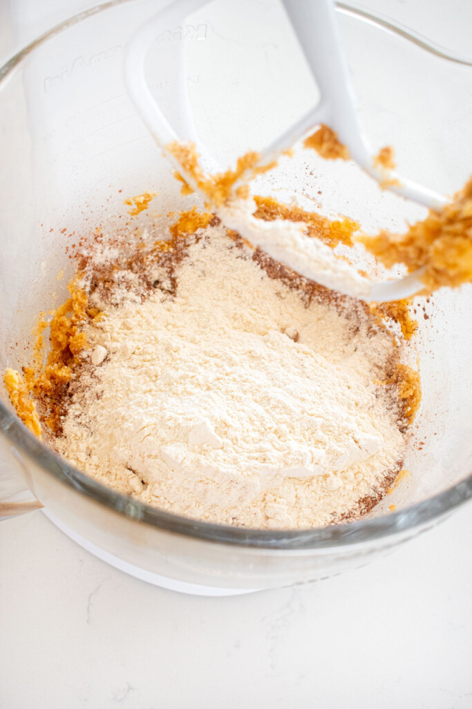 ingredients for chocolate sea salt cookie dough in a glass mixing bowl on a marble counter.