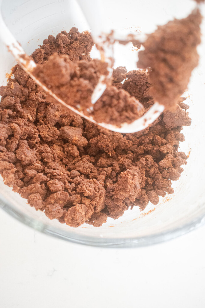 chocolate sea salt cookie dough in a glass mixing bowl on a marble counter.