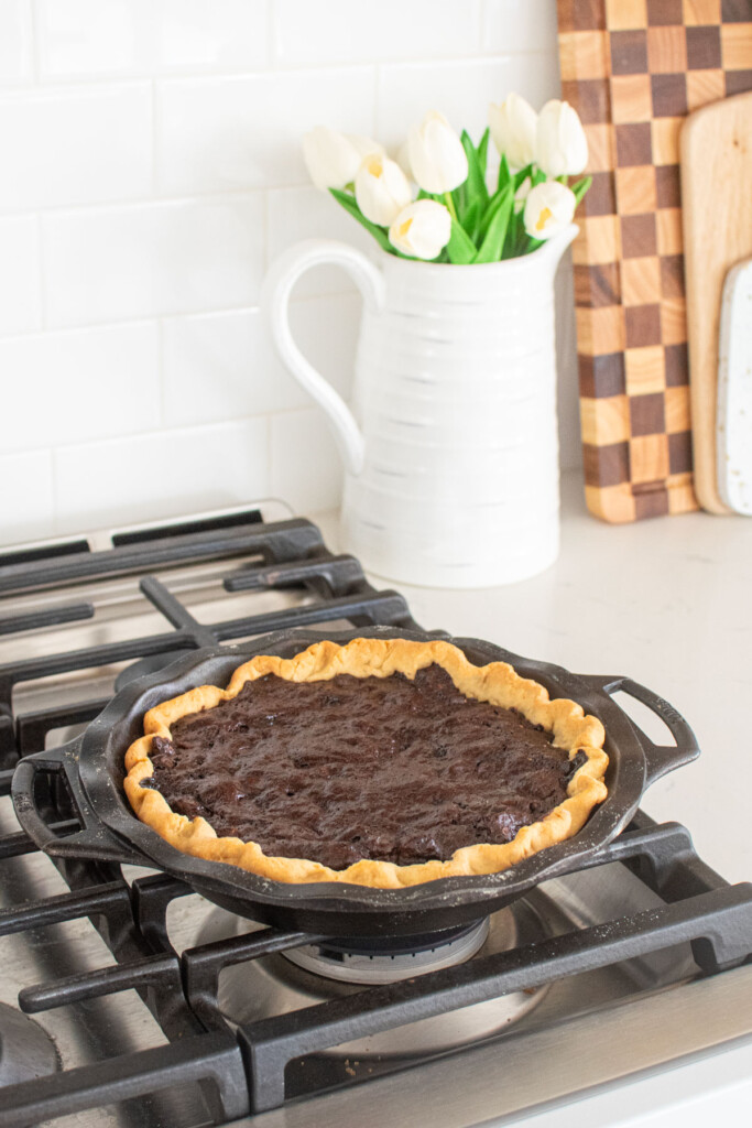 chocolate bourbon pecan pie cooling on top of an oven.