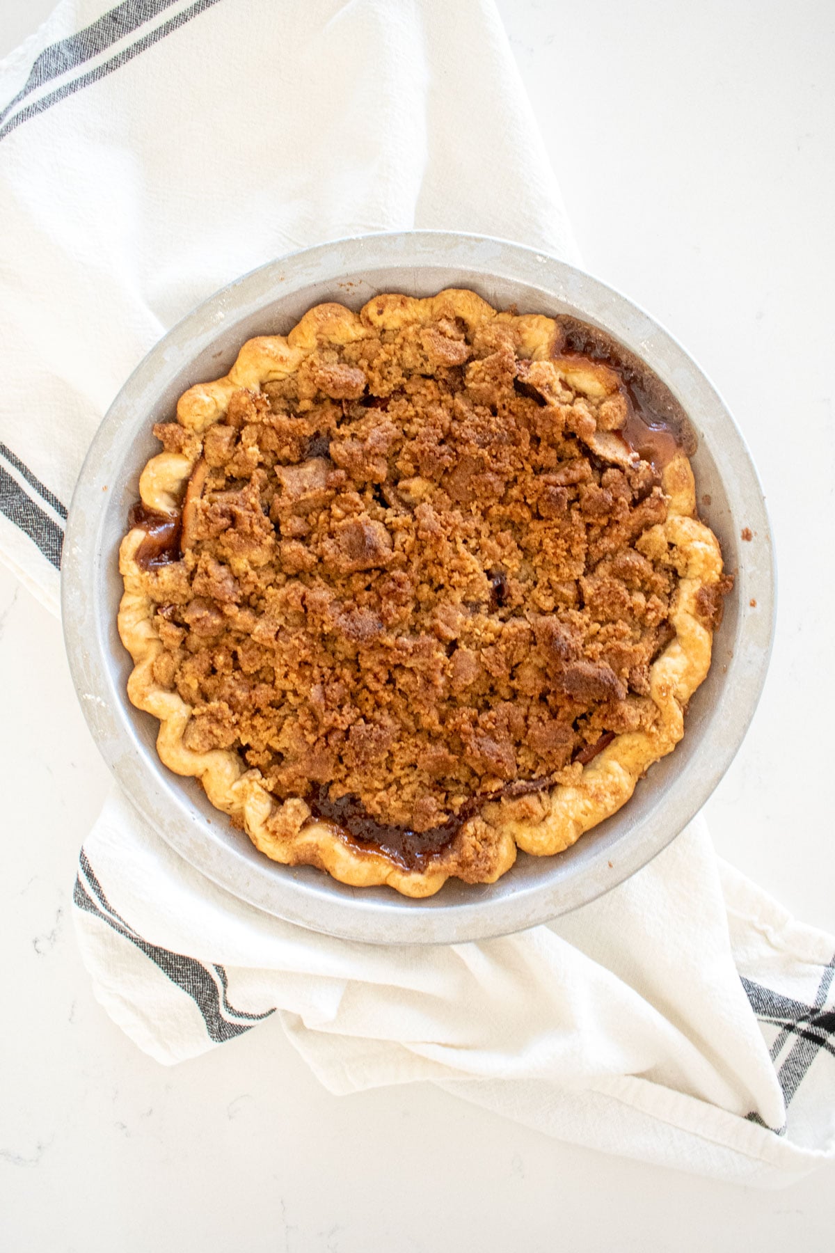 dutch apple pie on a white marble counter.