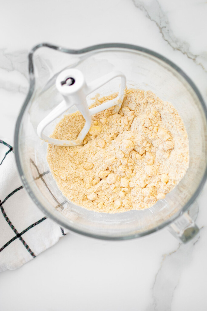 pie dough mixed together in the bowl of a mixer on a white countertop.