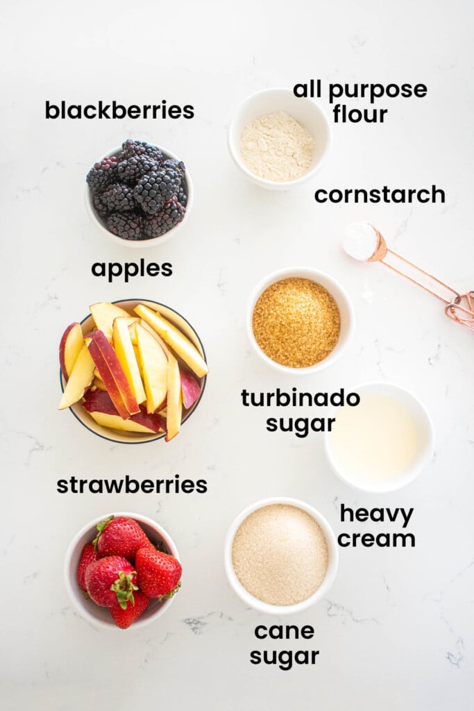 individual ingredients for apple berry pie laid out against a white background.