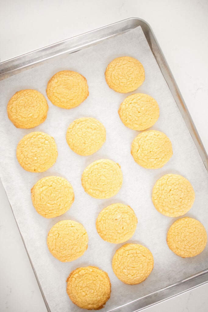 baked vanilla shortbread cookies on a baking sheet on a white marble countertop.