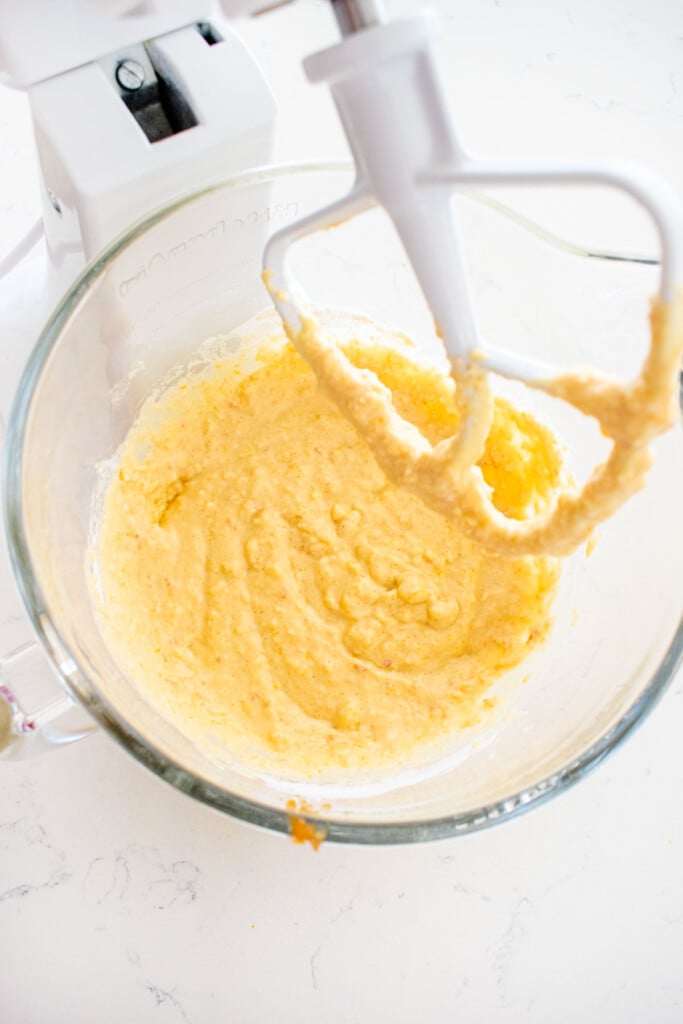 cranberry orange apple bread batter in a glass mixing bowl on a white marble counter.